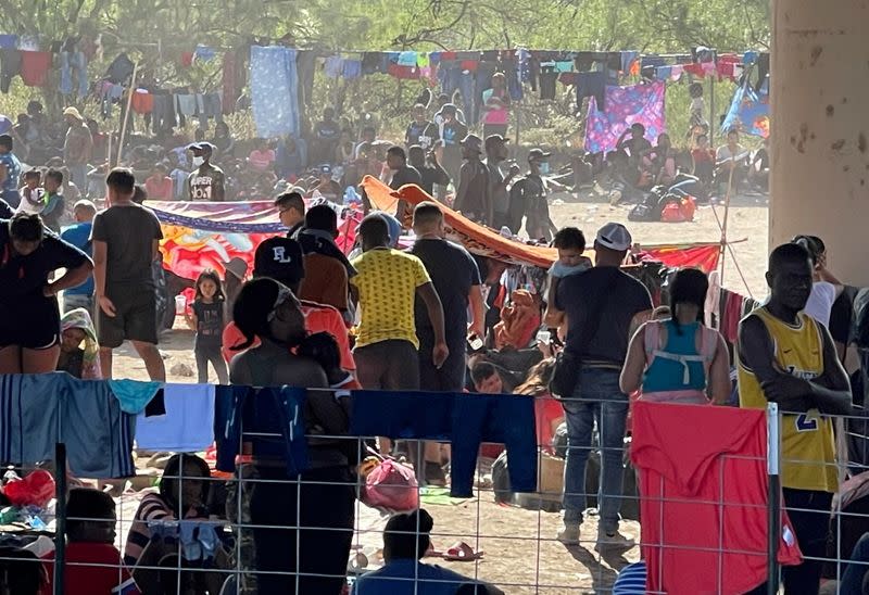 Migrants stand by the International Bridge between Mexico and the U.S., in Del Rio