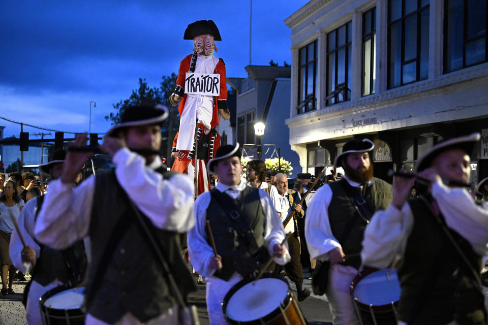 People in period costume carry an effigy of Benedict Arnold to be burned during the annual Burning of Benedict Arnold Festival, Saturday, Sept. 9, 2023, in New London, Conn. The burning of Arnold marks the anniversary of the day in September 1781 that the Connecticut native led British troops into the city and burned most of it to the ground. (AP Photo/Jessica Hill)