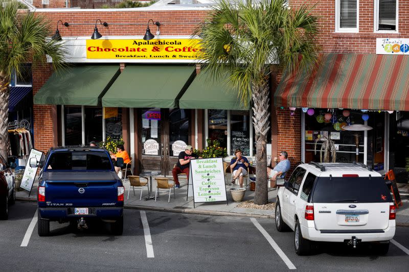 Patrons enjoy the day outside the Apalachicola Chocolate and Coffee Company in Apalachicola, Florida, U.S.