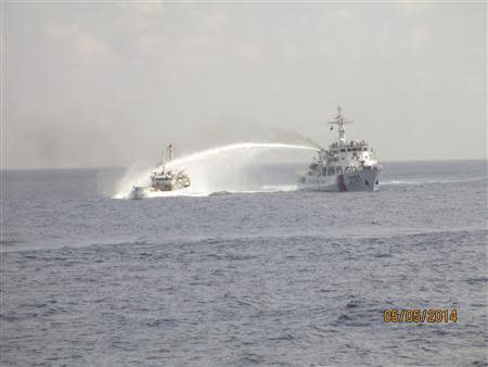 A Chinese ship (R) uses water cannon on a Vietnamese Sea Guard ship on the South China Sea near the Paracels islands, in this handout photo taken on May 5, 2014 and released by the Vietnamese Marine Guard on May 8, 2014. REUTERS/Vietnam Marine Guard/Handout via Reuters