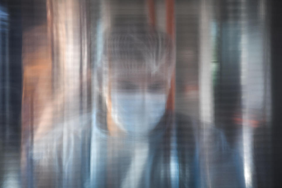 A medical worker is seen through a plastic panel in a bus that will serve as a mobile COVID-19 vaccination unit in Bucharest, Romania, Saturday, Sept. 4, 2021. The inhabitants of Romania's capital will be able to get a Johnson&Johnson COVID-19 vaccine without an appointment in the latest attempt by Romanian authorities to increase vaccination rates as the number of infections is on a constant rise in the country. (AP Photo/Andreea Alexandru)