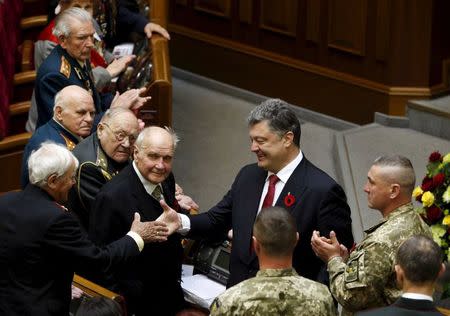 Ukrainian President Petro Poroshenko welcomes World War Two veterans during a session of the parliament in Kiev, Ukraine May 8, 2015. REUTERS/Valentyn Ogirenko