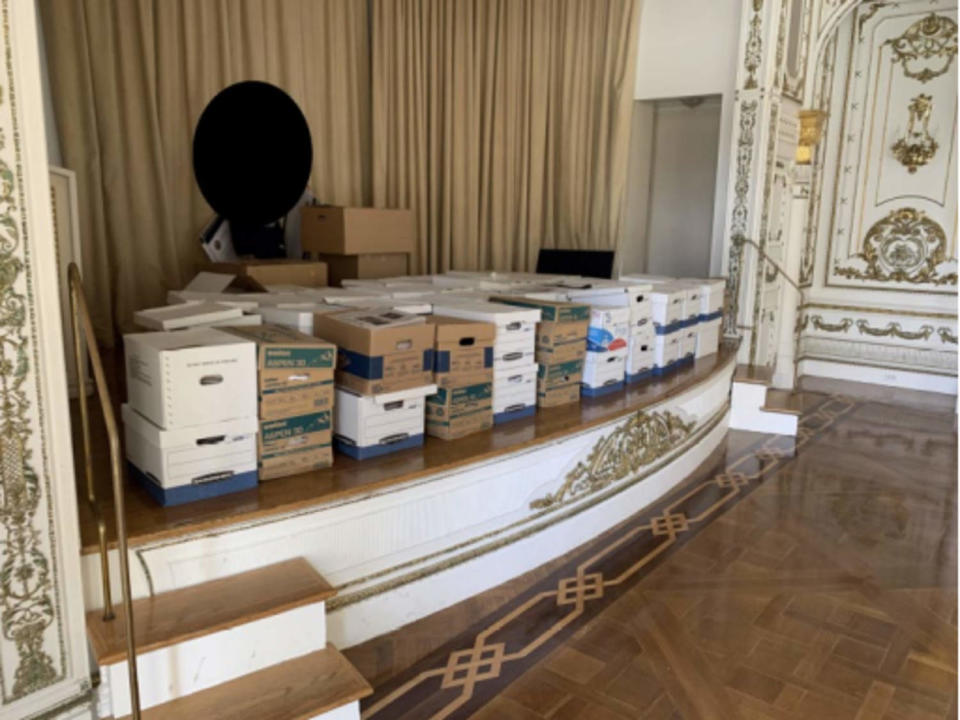 This image, contained in the indictment against former President Donald Trump, shows boxes of records being stored on the stage in the White and Gold Ballroom at Trump's Mar-a-Lago estate in Palm Beach, Fla. Trump is facing 37 felony charges related to the mishandling of classified documents according to an indictment unsealed Friday, June 9, 2023. (Justice Department via AP) (Justice Department via AP)