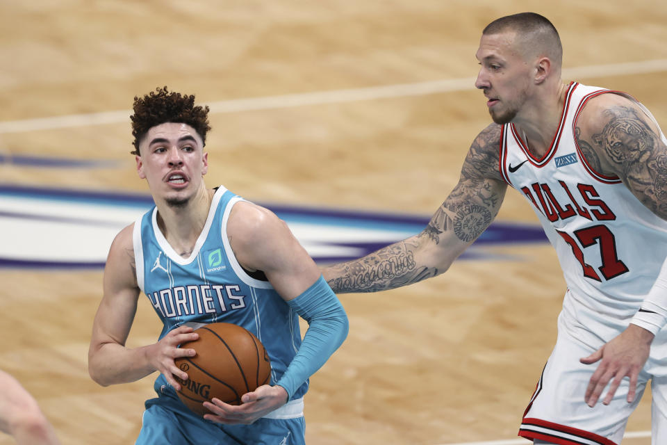 Charlotte Hornets guard LaMelo Ball, left, drives to the basket next to Chicago Bulls center Daniel Theis during the first half of an NBA basketball game in Charlotte, N.C., Thursday, May 6, 2021. (AP Photo/Nell Redmond)