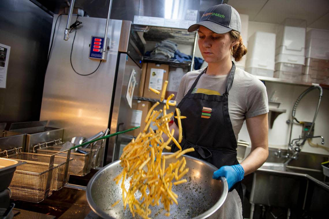 Chef Kayla Murray seasons french fries Thursday, Nov. 14, 2019, at Burger Patch restaurant in midtown, where the co-owner Danea Horn has started an organization called Gril Power, to heighten awareness of women working in kitchens.