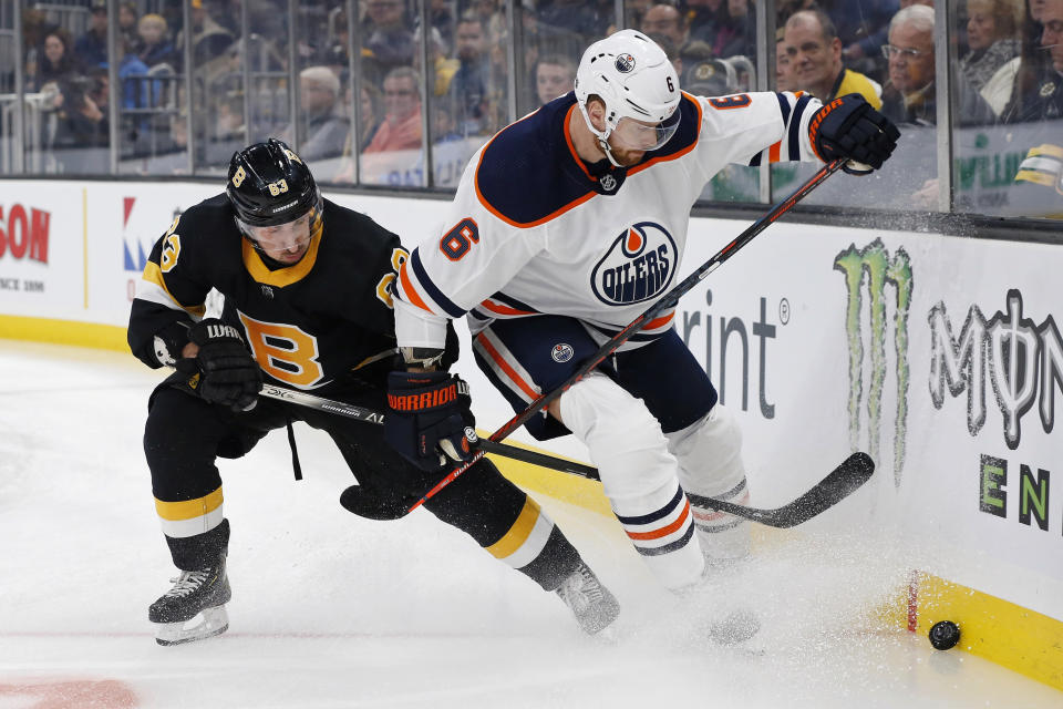 Boston Bruins' Brad Marchand (63) battles Edmonton Oilers' Adam Larsson (6) for the puck during the first period on an NHL hockey game in Boston, Saturday, Jan. 4, 2020. (AP Photo/Michael Dwyer)