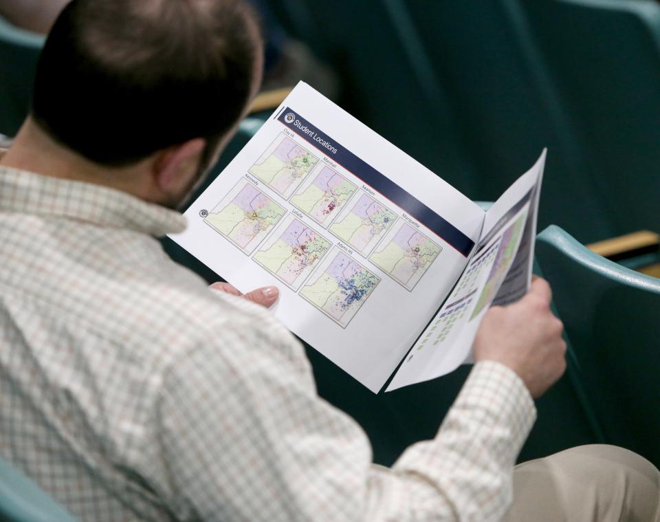A man looks over documents Tuesday, Feb. 7, 2023, at the information session for the South Bend school district’s long-range facilities master plan at Edison Intermediate Center in South Bend.
