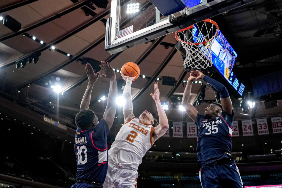 Texas guard Chendall Weaver (2) shoots over UConn guard Hassan Diarra (10) and forward Samson Johnson (35) during the first half of an NCAA college basketball game in the final of the Empire Classic tournament in New York, Monday, Nov. 20, 2023. (AP Photo/Peter K. Afriyie)