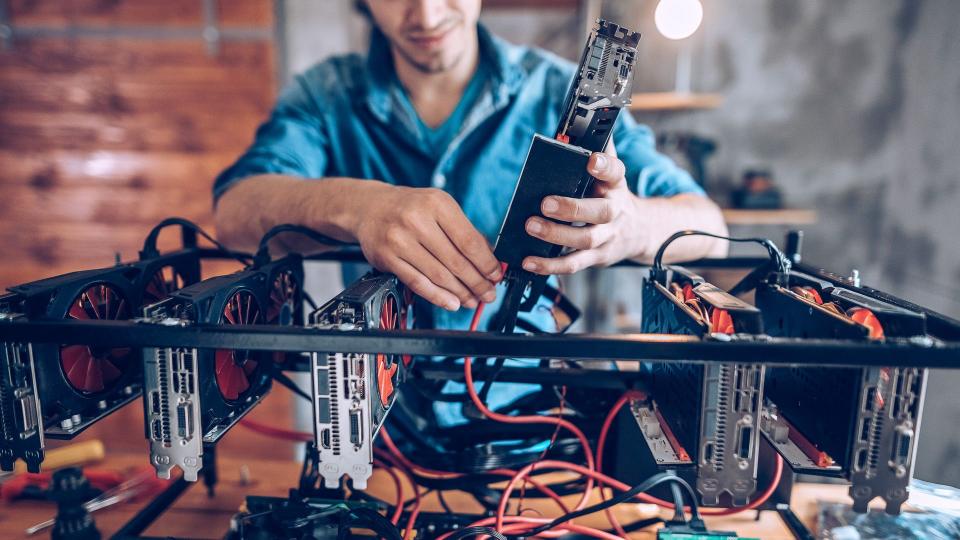 Programmer preparing mining rig with GPU.