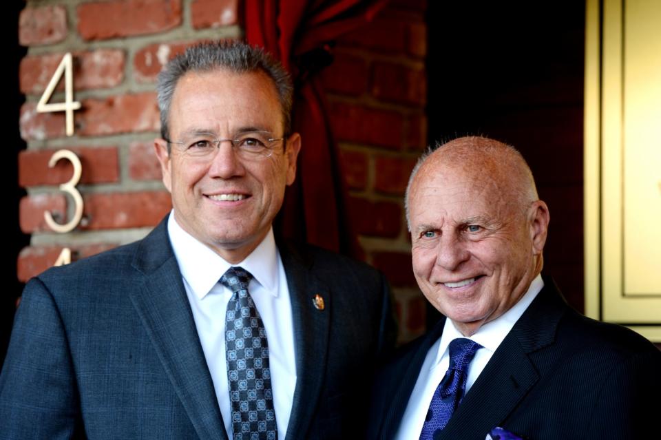 Michel Moore and Tom Girardi stand side by side and smile for a photo.