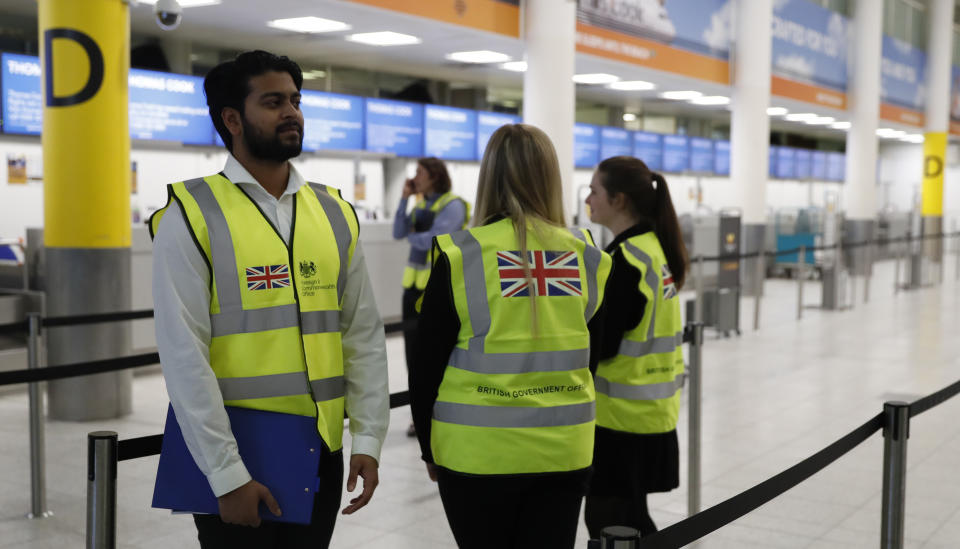 British Foreign Office personnel stand by the entrance to Thomas Cook check-in desks in Gatwick Airport, England Monday, Sept. 23, 2019. British tour company Thomas Cook collapsed early Monday after failing to secure emergency funding, leaving tens of thousands of vacationers stranded abroad. (AP Photo/Alastair Grant)