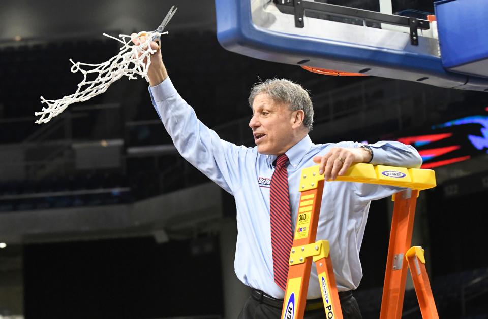 DePaul head coach Doug Bruno cuts down the net after the Blue Demons took down Marquette in the Big East title game.