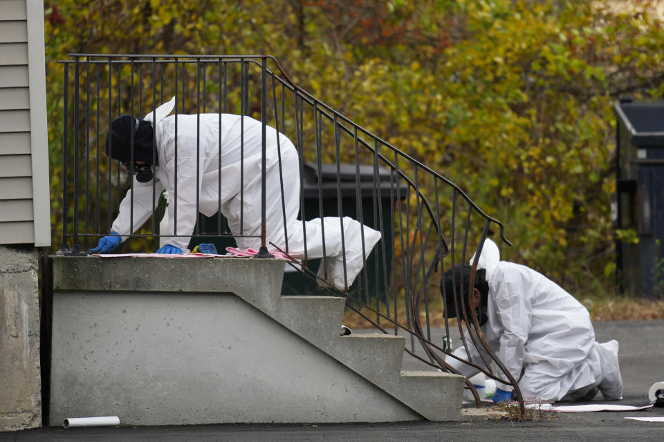 A hazmat team cleans steps leading into Schemengees Bar & Grille, Sunday, Oct. 29, 2023, in Lewiston, Maine. The community is working to heal following mass shootings at the bar and a bowling alley in Lewiston on Wednesday, Oct. 25. (AP Photo/Matt Rourke)