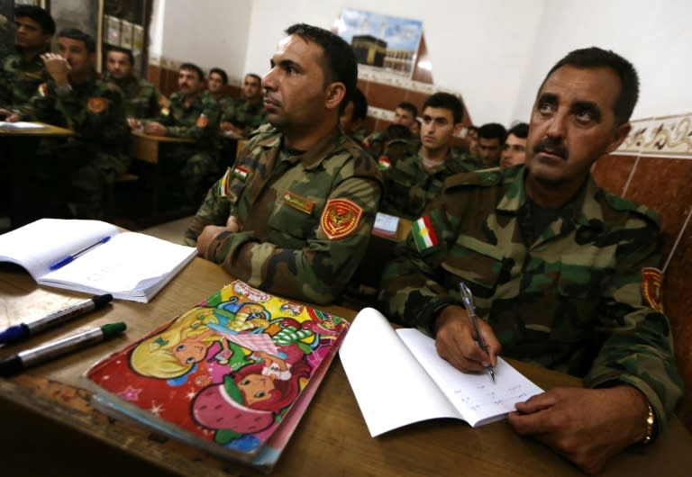 Iraqi Kurdish peshmerga fighters attend a class at a school in the northern Iraqi village of Bahra, some three kilometres from the closest Islamic State group position, on June 16, 2015