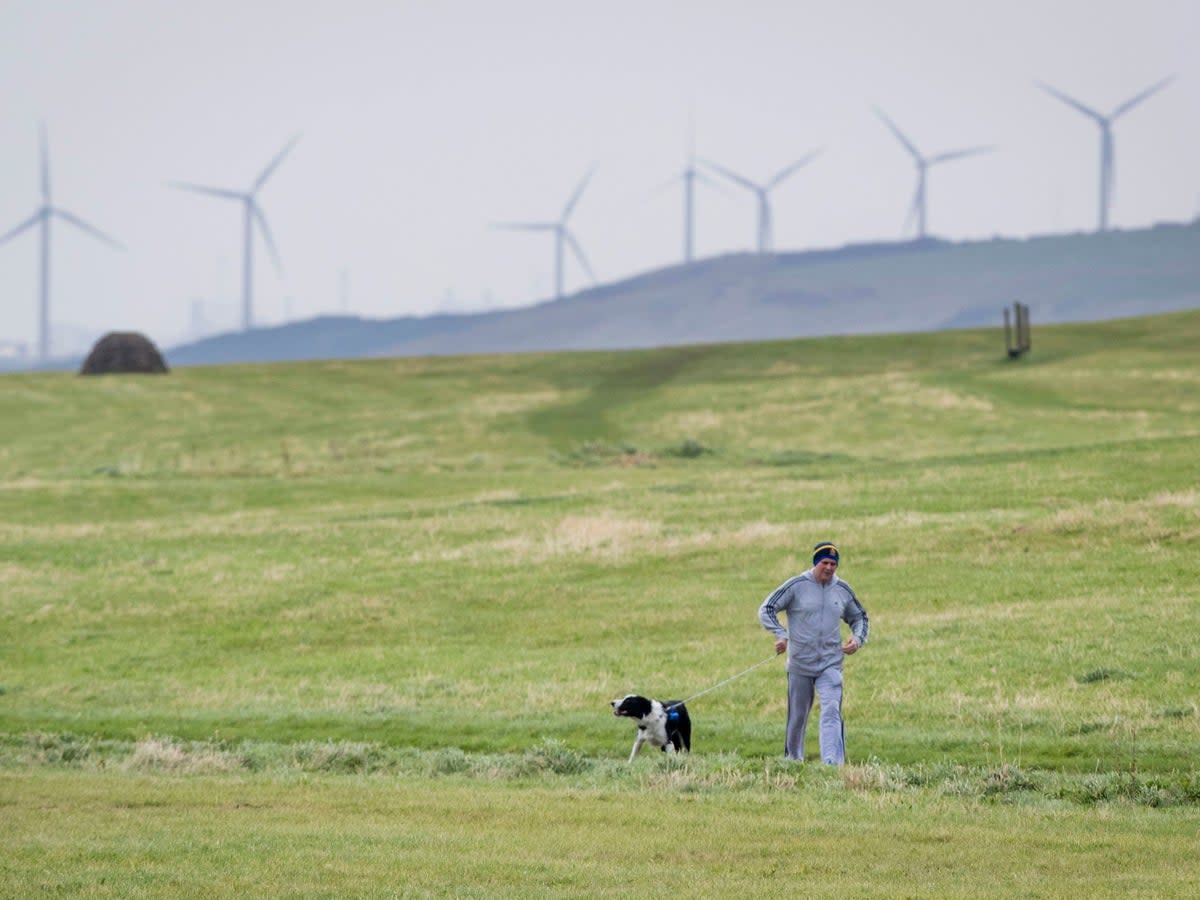 Going back in time. A man walks his dog in Whitehaven, Cumbria, near the site of the proposed coal mine  (PA)