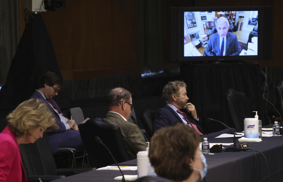 Senators listen as Dr. Anthony Fauci, director of the National Institute of Allergy and Infectious Diseases, speaks remotely during a virtual Senate Committee for Health, Education, Labor, and Pensions hearing, Tuesday, May 12, 2020 on Capitol Hill in Washington. Seated at table on left are Sen. Lisa Murkowski, R-Alaska, Sen. Mike Braun, R-Ind., center, and Sen. Rand Paul, R-Ky. (Win McNamee/Pool via AP)