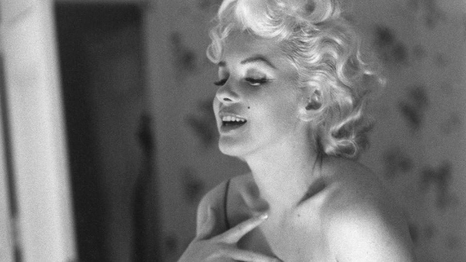 Marilyn Monroe applying Chanel No. 5 perfume while getting ready to see the play "Cat On A Hot Tin Roof." - Ed Feingersh/Michael Ochs Archives/Getty Images/Courtesy V&A