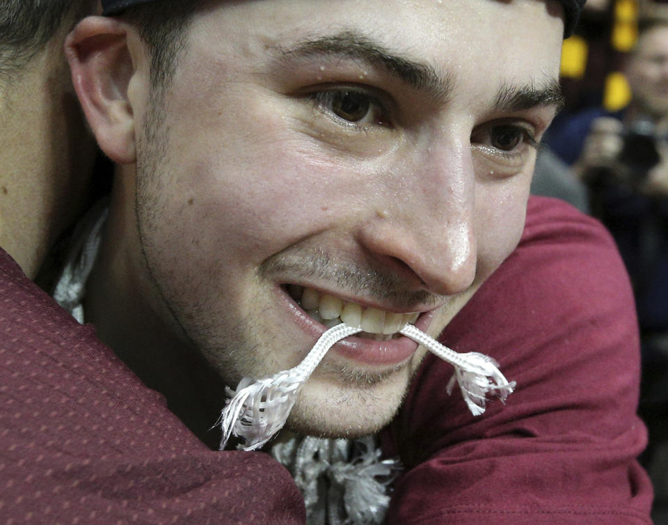 Loyola Chicago’s Ben Richardson chews on a piece of net after reaching the Final Four. (Curtis Compton/Atlanta Journal-Constitution via AP)