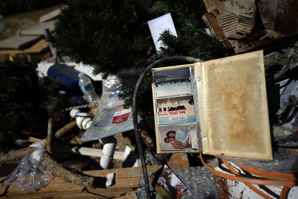 Photographs lie on a pile of water-damaged trash and debris next to the devastated Getaway Marina, following the passage of Hurricane Ian, on San Carlos Boulevard in Fort Myers Beach, Fla., Sunday, Oct. 2, 2022.