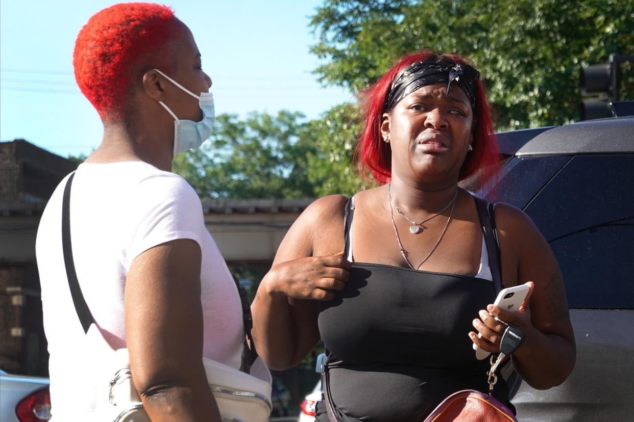 Friends and family look for information at the scene of a shooting on June 15, 2021 in the Englewood neighborhood of Chicago, Illinois. Four people were killed at a home during an early-morning shooting and four others who were injured were transported to the hospital.