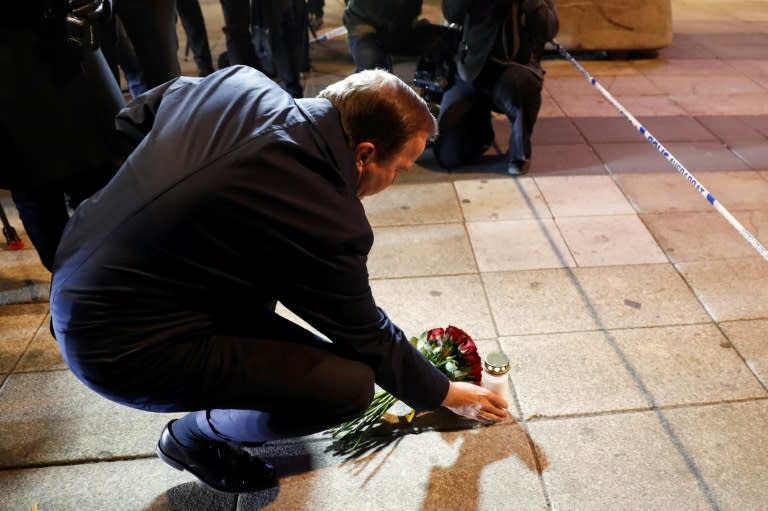 Swedish Prime Minister Stefan Lofven lays flowers and a candle at the scene of a truck attack that killed four people in central Stockholm on April 7, 2017
