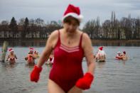 Members of the Berliner Seehunde (Berlin Seals) ice swimmers club take a dip in Lake Orankesee during their traditional Christmas swimming event in Berlin, December 25, 2013. REUTERS/Thomas Peter (GERMANY - Tags: SOCIETY)