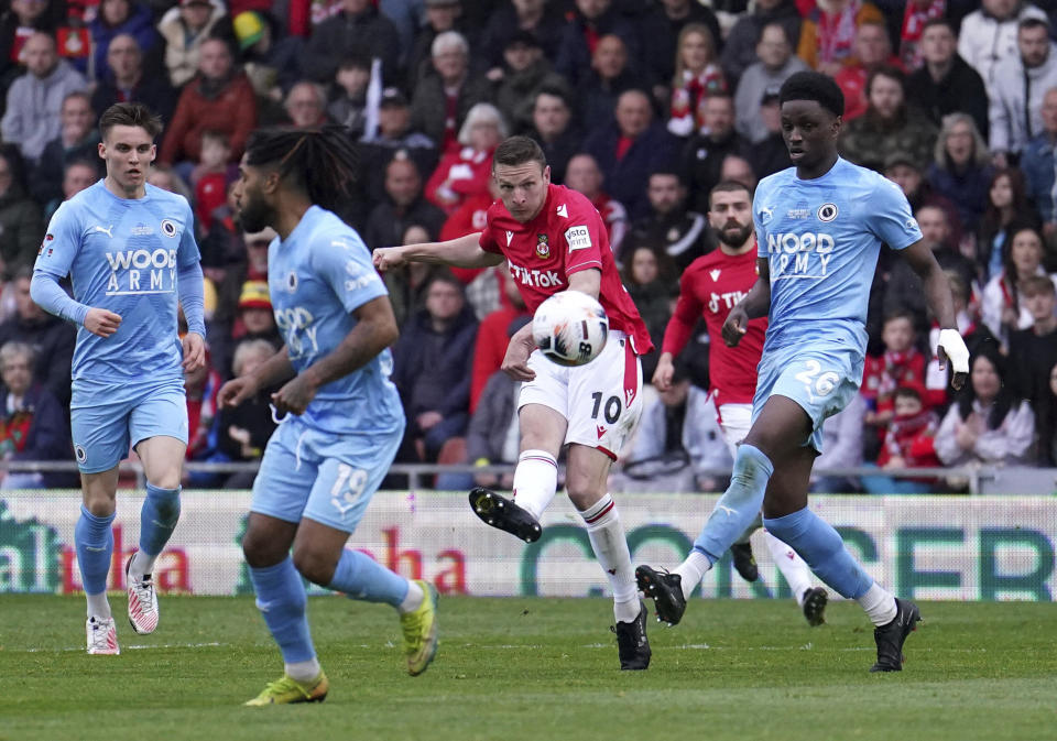 Wrexham's Paul Mullin, center, Scores their side's second goal of the game during the National League soccer match between Wrexham and Boreham Wood at The Racecourse Ground, in Wrexham, Wales, Saturday April 22, 2023. (Martin Rickett/PA via AP)