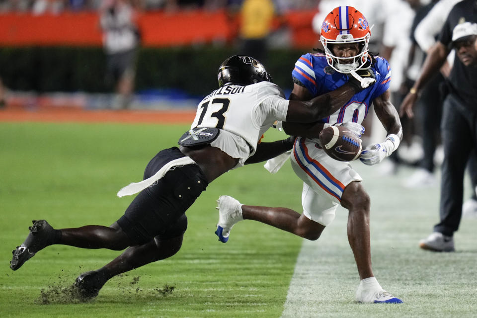 Central Florida defensive back Ladarius Tennison (13) breaks up a pass intended for Florida wide receiver Tank Hawkins (10) during the first half of an NCAA college football game, Saturday, Oct. 5, 2024, in Gainesville, Fla. (AP Photo/John Raoux)