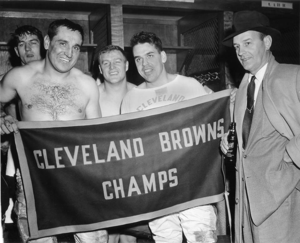 In this Dec. 12, 1954, file photo, Cleveland Browns, from left, Pete Brewster, Lou Groza, Chuck Noll, Otto Graham and coach Paul Brown pose in the dressing room after defeating the Pittsburgh Steelers to win the East divisional championship. The Cleveland Browns won the NFL title in their first year in the league (1950) and added championships in 1954-55. (AP Photo/Julian C. Wilson, File)