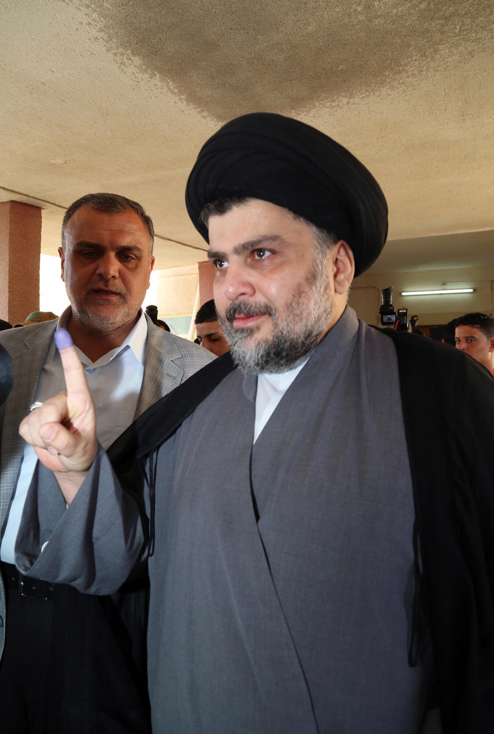 Shiite cleric Muqtada al-Sadr shows an ink-stained finger after casting his vote at a polling station in the Shiite holy city of Najaf, 100 miles (160 kilometers) south of Baghdad, Iraq, Wednesday, April 30, 2014. Iraq is holding its third parliamentary elections since the U.S.-led invasion that toppled dictator Saddam Hussein. More than 22 million voters are eligible to cast their ballots to choose 328 lawmakers out of more than 9,000 candidates. (AP Photo/Jaber al-Helo)