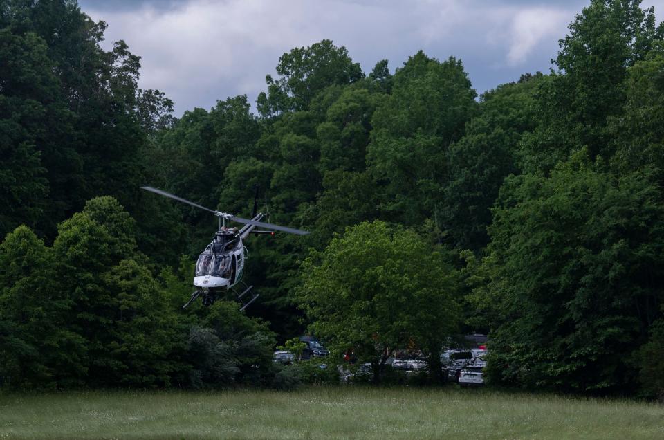 A helicopter takes flight nearby where first responders are gathered following a plane crash where three people were killed in Williamson County, Tenn., Wednesday, May 15, 2024. The plane departed from Baton Rouge, Louisiana and was headed to Louisville, Kentucky when it crashed.