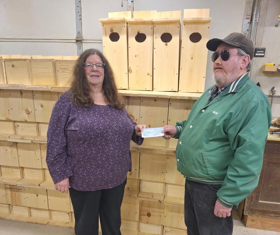 Lynn Robinson (left), representing the Green Bay Duck Hunters, presents a check to Bob Schuh to go toward the purchase of additional supplies for building wood duck houses.