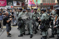 Protesters face off with police in Hong Kong on Sunday, Sept. 29, 2019. Protesters chanted slogans and heckled police as they were pushed back behind a police line. (AP Photo/Vincent Thian)