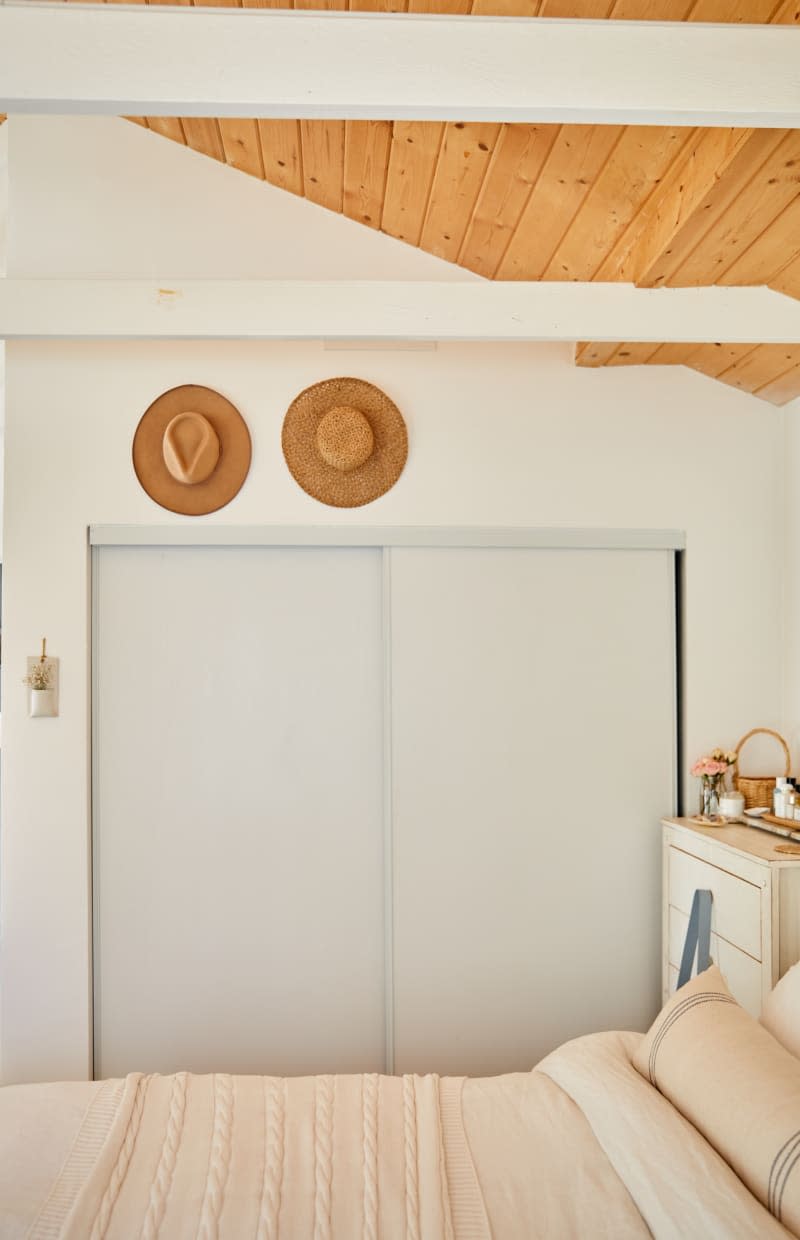 Two sunhats over a sliding door closet.