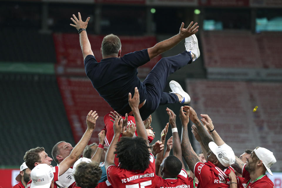 Los jugadores del Bayern Múnich lanzan por los aires a su técnico Hans-Dieter Flick, tras ganar la final de la Copa de Alemania al Bayer Leverkusen, el sábado 4 de julio de 2020 en Berlín (AP Foto/Michael Sohn)