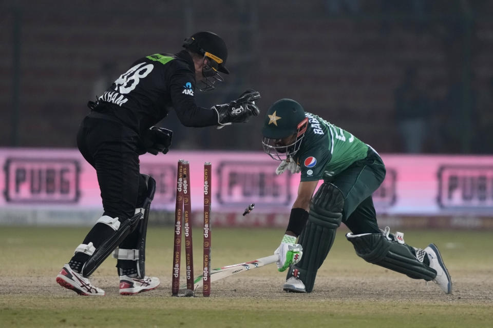 Pakistan's Babar Azam, right, attempts unsuccessfully save his stump out by New Zealand's Tom Latham during the first one-day international cricket match between Pakistan and New Zealand, in Karachi, Pakistan, Monday, Jan. 9, 2023. (AP Photo/Fareed Khan)