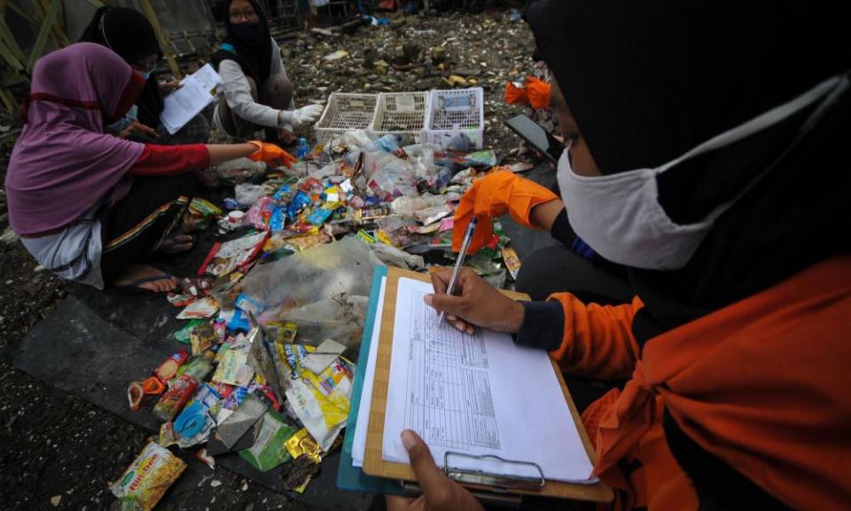 Indonesian students pick up plastic waste during clean up on the coast of Surabaya.