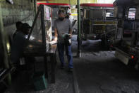 A man shows his vaccination card before riding a passenger jeep at a terminal in Quezon city, Philippines on Monday, Jan. 17, 2022. People who are not fully vaccinated against COVID-19 were banned from riding public transport in the Philippine capital region Monday in a desperate move that has sparked protests from labor and human rights groups. (AP Photo/Aaron Favila)