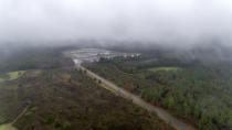 The Stewart Detention Center sits surrounded by woods, Friday, Nov. 15, 2019, in Lumpkin, Ga. About 140 miles southwest of Atlanta, the razor-wire ringed detention center stands beige and grey in the green outskirts of tiny Lumpkin, where detainees outnumber residents. (AP Photo/David Goldman)