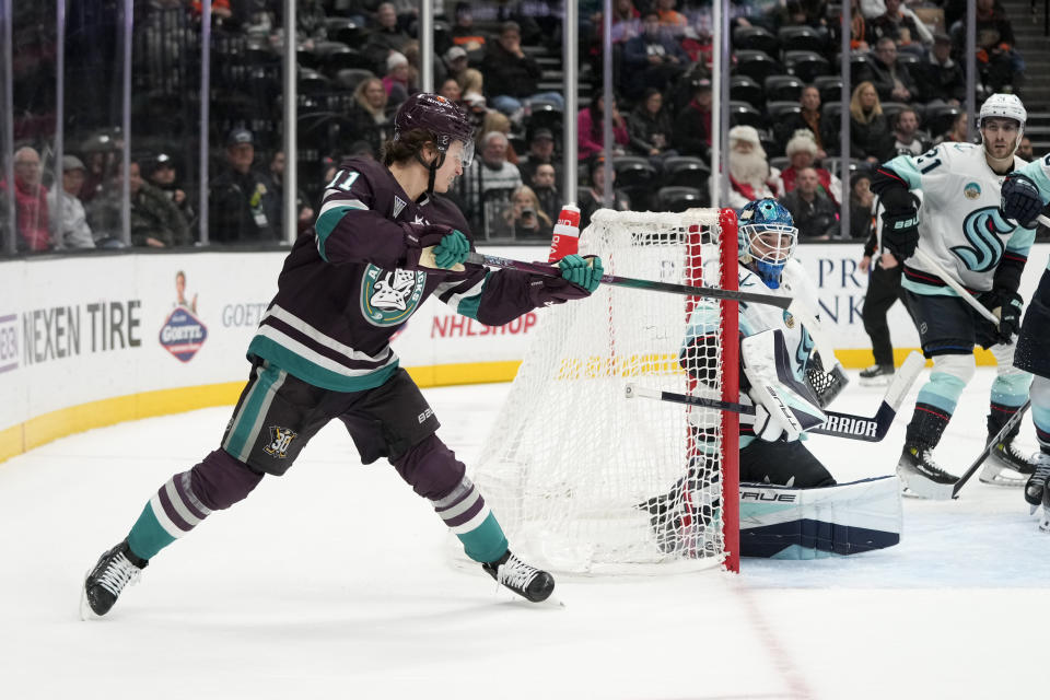 Anaheim Ducks center Trevor Zegras (11) bats the puck in for a goal against Seattle Kraken goaltender Joey Daccord during the third period of an NHL hockey game Saturday, Dec. 23, 2023, in Anaheim, Calif. (AP Photo/Jae C. Hong)