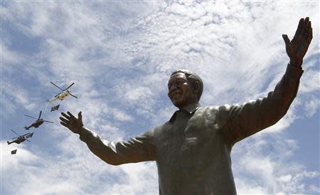 Helicopters fly past a 9-metre bronze statue of the Nelson Mandela after it was unveiled as part of the Day of Reconciliation Celebrations at the Union Buildings in Pretoria