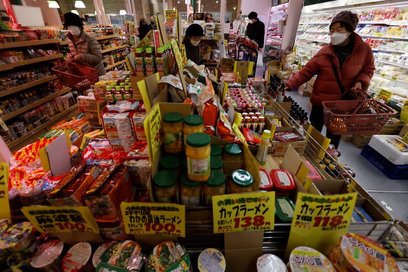 Shoppers check food items at a supermarket in Tokyo