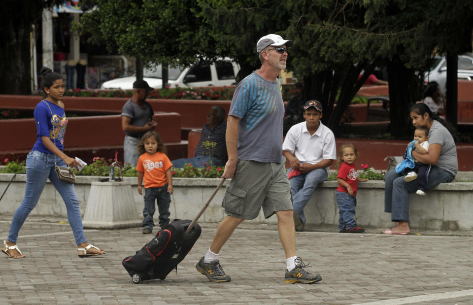 This May 27, 2013 photo shows a tourist walking with his backpack in a plaza in Boquete west of Panama City. Panama has become a hot spot for American retirees. They come for the natural beauty, the weather and, perhaps more important, the low cost of living. (AP Photo/Arnulfo Franco)