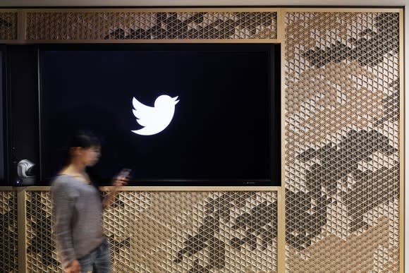 Woman walking by the Twitter logo