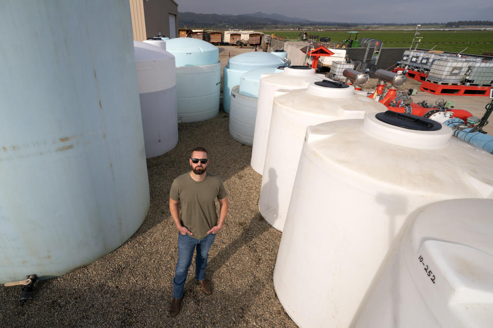William Terry, of Terry Farms, poses among fertilizer tanks at his farm Thursday, March 31, 2022, in Oxnard, Calif. Terry Farms, which grows produce on 2,100 acres largely, has seen prices of some fertilizer formulations double; others are up 20%. (AP Photo/Mark J. Terrill)