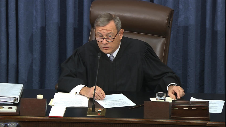 In this image from video, presiding officer Chief Justice of the United States John Roberts gets a card with the question submitted by Sen. Rand Paul, R-Ky., aside as declines to read the question as written during the impeachment trial against President Donald Trump in the Senate at the U.S. Capitol in Washington, Thursday, Jan. 30 2020. (Senate Television via AP)