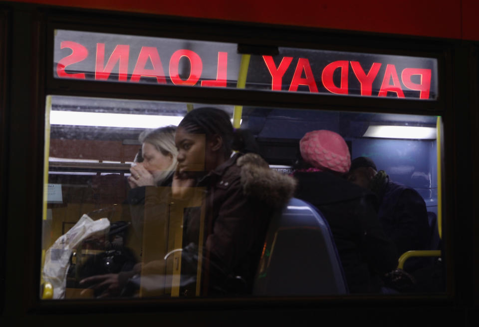 LONDON, ENGLAND - JANUARY 11:  A neon sign above a branch of Payday Loans, who offer cash for gold and instant cheque cashing services, is reflected in a bus window on January 11, 2011 in London, England. The Government's budget cuts are placing an increasing strain on the finances and job security of many citizens. Chancellor George Osborne is encouraging banks to reduce the size of their annual staff bonuses.  (Photo by Oli Scarff/Getty Images)