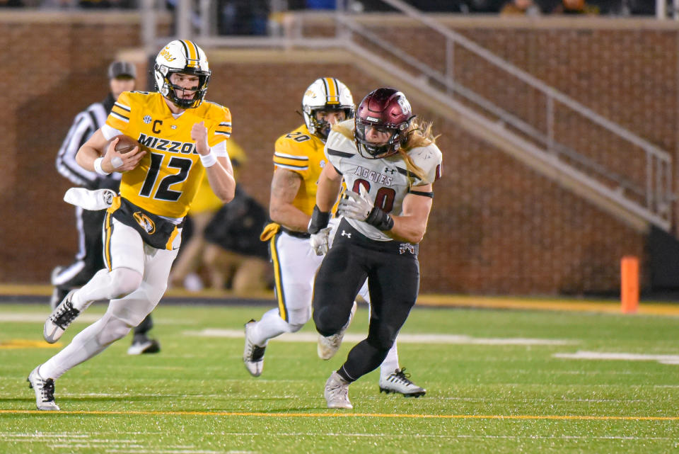 COLUMBIA, MO - NOVEMBER 19: Missouri Tigers quarterback Brady Cook (12) runs for a first down while being chased by New Mexico State Aggies linebacker Trevor Brohard (80) during a non conference game between the New Mexico State Aggies and the Missouri Tigers held on Saturday NOV 19, 2022 at Faurot Field at Memorial Stadium in Columbia MO. (Photo by Rick Ulreich/Icon Sportswire via Getty Images