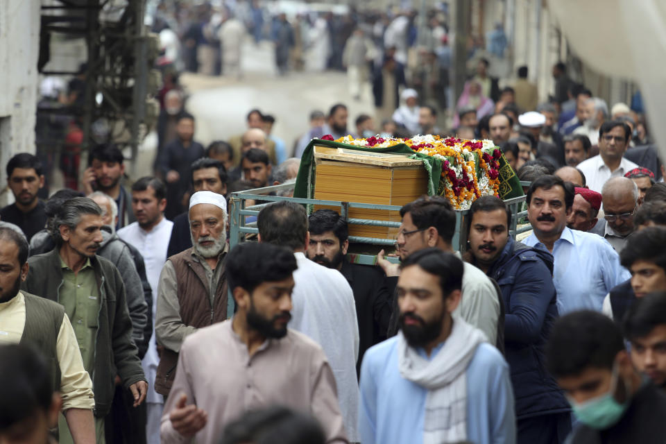 People carries the coffin of a victim of Friday's suicide bombing in Peshawar, Pakistan, Saturday, March 5, 2022. The Islamic State says a lone Afghan suicide bomber struck inside a Shiite Muslim mosque in Pakistan's northwestern city of Peshawar during Friday prayers, killing dozens worshippers and wounding more than 190 people. (AP Photo/Muhammas Sajjad)