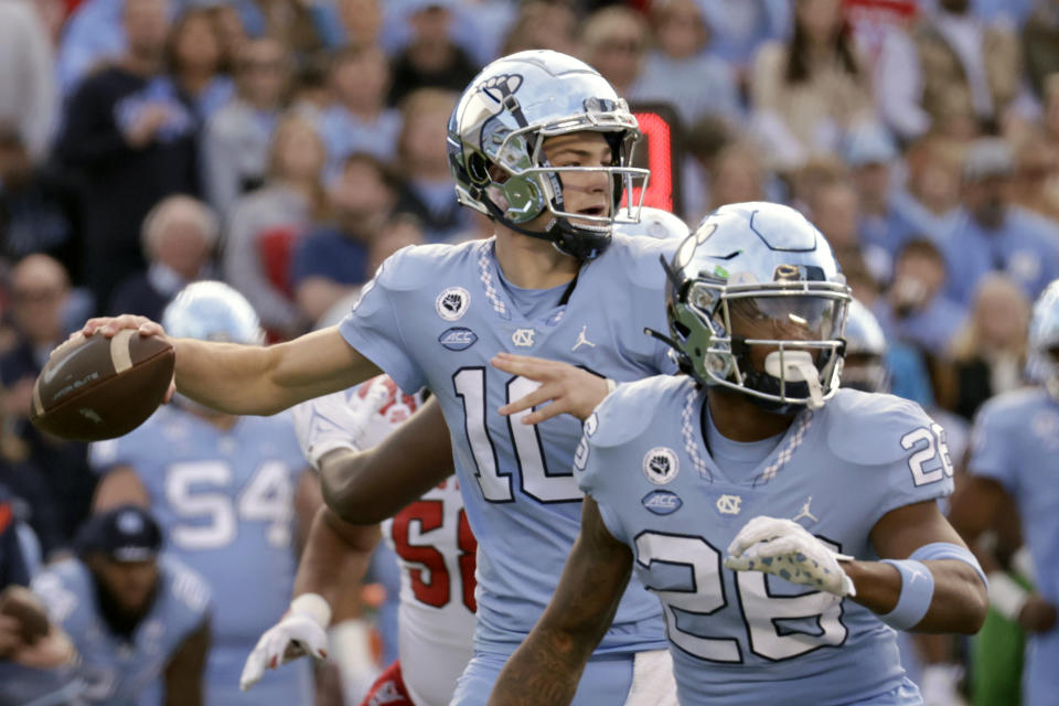 North Carolina quarterback Drake Maye (10) looks to pass against North Carolina State behind the block of running back Omarion Hampton (28) during the first half of an NCAA college football game Friday, Nov. 25, 2022, in Chapel Hill, N.C. (AP Photo/Chris Seward)